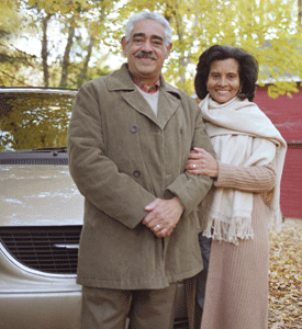 Photo of a couple standing in front of a car
